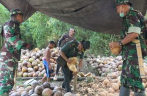 Tim Wasev TMMD Unjuk Kebolehan Mengupas Kelapa Saat Kunjungan ke Desa Ogoalas